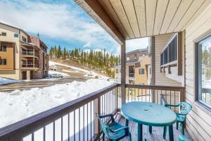 a balcony with a blue table and two chairs at Downhill Beaverhead in Big Sky