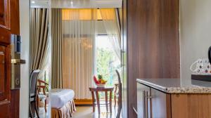 a kitchen with a window and a table with a stool at Millsview Hotels in Kisumu in Kisumu