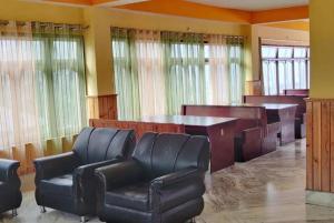 a waiting room with leather chairs and a table at Pelling Hotel Ladakh House in Pelling