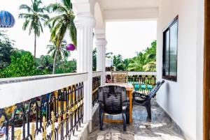a balcony with a table and chairs and palm trees at Pelling Hotel Ladakh House in Pelling