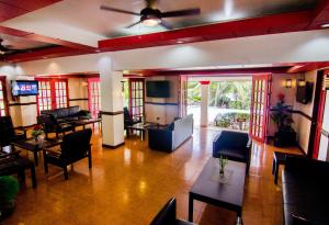 a living room with chairs and tables and windows at Grand Luis Mountain Resort in Dauis