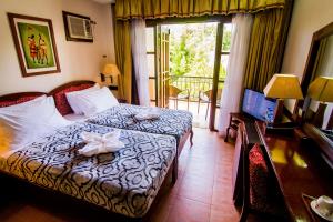 DauisにあるGrand Luis Mountain Resortのベッドとバルコニー付きのホテルルーム