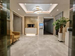 una hall con ufficio e soffitto con lampadario pendente di Trevi Hotel a Jeju