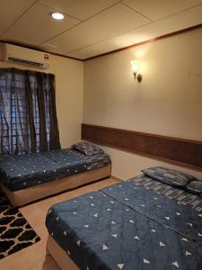 een kamer met 2 bedden in een kamer met bij A'Famosa Villa 884 in Kampong Alor Gajah