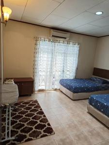 een grote kamer met 2 bedden en een tapijt bij A'Famosa Villa 884 in Kampong Alor Gajah