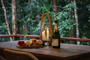 a wooden table with a bottle of wine and glasses at Narrows Escape Rainforest Retreat in Montville