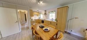 eine Küche mit einem Holztisch und Stühlen im Zimmer in der Unterkunft Portnellan in Crianlarich