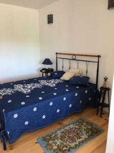 1 dormitorio con 1 cama con edredón azul y alfombra en Grandfather's House, en Tábua