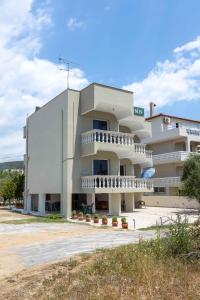 a large white building with balconies on it at Pansion Artemis in Mavrovouni