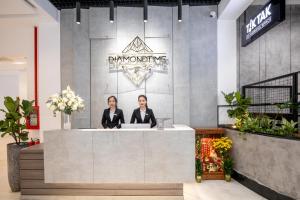 ダナンにあるFlexi Hotel & Apartmentの店のカウンターに立つ二人