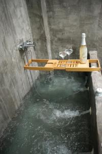 a bathtub with two glasses of wine and water at Terra Petra in Sfakaki