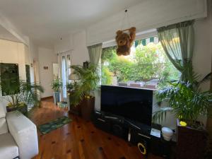 ein Wohnzimmer mit einem Flachbild-TV und Pflanzen in der Unterkunft Terrazza Milano Apartment in Mailand