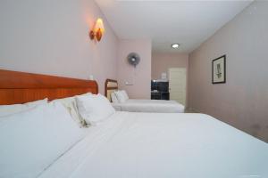 a bedroom with two beds with white sheets at Mila Motel 2 in Pantai Cenang