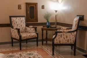 uma sala de estar com duas cadeiras e uma mesa em Tree of Life Darbargadh Dared em Bhavnagar