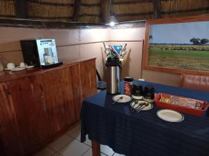 a table with a blue table cloth and a coffee maker at Divundu Guest House in Divundu +42 photos