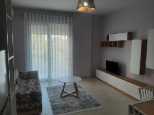 a living room with a table and a television at Linda’s apartment in Vlorë