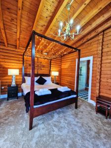 Dormitorio con cama con dosel en una cabaña de madera en Kaoglen-Stags-Hot tub-Cairngorms-Pet Friendly, en Balnald