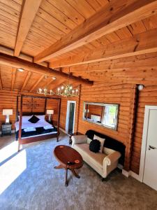 um quarto com uma cama, um sofá e uma mesa em Kaoglen-Stags-Hot tub-Cairngorms-Pet Friendly em Balnald