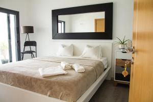 a bedroom with a large bed with towels on it at Villa Secret Spot Luxury in Lourinhã
