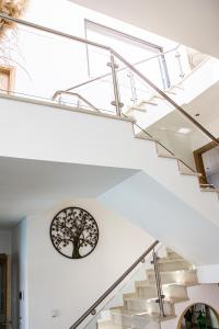 a white staircase with a tree clock on the wall at Villa Secret Spot Luxury in Lourinhã