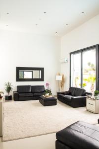 ein Wohnzimmer mit zwei schwarzen Sofas und einem Teppich in der Unterkunft Villa Secret Spot Luxury in Lourinhã