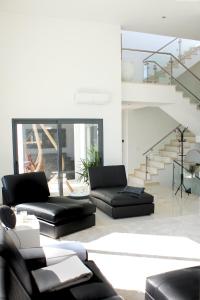 ein Wohnzimmer mit schwarzen Möbeln und einer Treppe in der Unterkunft Villa Secret Spot Luxury in Lourinhã