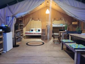 namiot z łóżkiem, stołem i krzesłami w obiekcie Tente Lodge Safari w mieście Saint-Martin-des-Besaces