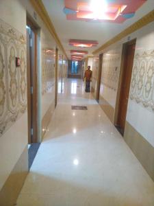 Un uomo che cammina lungo un corridoio in un edificio di New City Tower Residency a Tiruchchendūr
