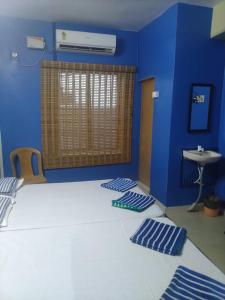 Habitación azul con cama y lavamanos en New City Tower Residency, en Tiruchchendūr