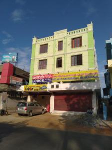 un edificio con un'auto parcheggiata di fronte di New City Tower Residency a Tiruchchendūr