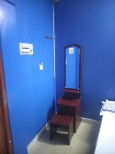 a bathroom with a blue wall and a mirror at New City Tower Residency in Tiruchchendūr