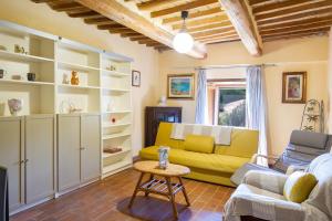 ein Wohnzimmer mit einem gelben Sofa und einem Tisch in der Unterkunft Quercia Grossa in Roccastrada