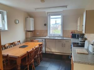 cocina con mesa de madera y ventana en Nelson Street Apartment en Inverness