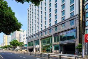 a large building on a city street with a street at Jeju Central City Hotel in Jeju
