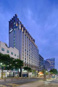 duży budynek z wieżą zegarową w mieście w obiekcie Jeju Central City Hotel w mieście Czedżu