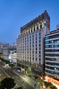 duży budynek na ulicy miejskiej w nocy w obiekcie Jeju Central City Hotel w mieście Czedżu
