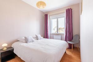 um quarto com uma cama branca e uma janela em Les Bleuets em Pléneuf-Val-André