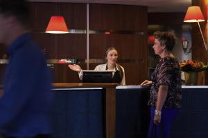 two women standing at a counter in a kitchen at Mercure Hotel Groningen Martiniplaza in Groningen