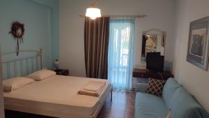 a bedroom with a bed and a couch and a television at Guesthouse Michobeis in Kamarína +51 photos
