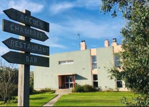 un palo con segnali stradali di fronte a un edificio di Auberge de Jeunesse HI Belle-Île-en-Mer a Le Palais