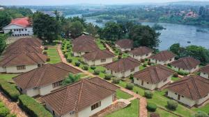 an aerial view of a village with roofs on the water at Jinja Nile Resort in Jinja