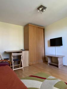 sala de estar con escritorio y TV en la pared en Apartament Myria en Constanza