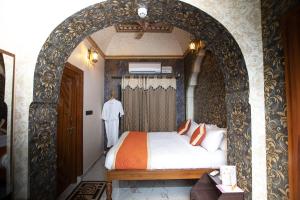 ein Schlafzimmer mit einem Torbogen und einem Bett darin in der Unterkunft Kavassu Heritage Haveli in Jhunjhunūn