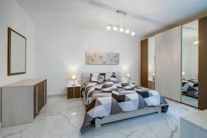 a bedroom with a bed with a black and white comforter at Deluxe Apartment steps to St Georges Bay in St Julian's +41 photos