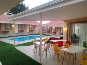a patio with tables and chairs next to a pool at Benoni N12 Hotel in Benoni