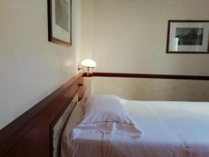 a bedroom with a bed and a lamp on the wall at Phi Hotel Dei Medaglioni in Correggio +116 photos