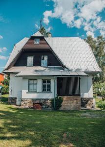 une grande maison avec un toit en métal sur une cour dans l'établissement Apartmány Rajschl - Železná Ruda, à Železná Ruda