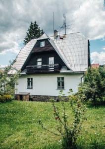 une grande maison blanche avec un toit en gambrel dans l'établissement Apartmány Rajschl - Železná Ruda, à Železná Ruda