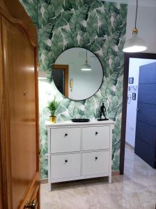 een badkamer met een witte dressoir en een spiegel bij La Brisa apartamento in Málaga