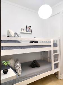 białe łóżko piętrowe w białym pokoju w obiekcie La Brisa apartamento w Maladze